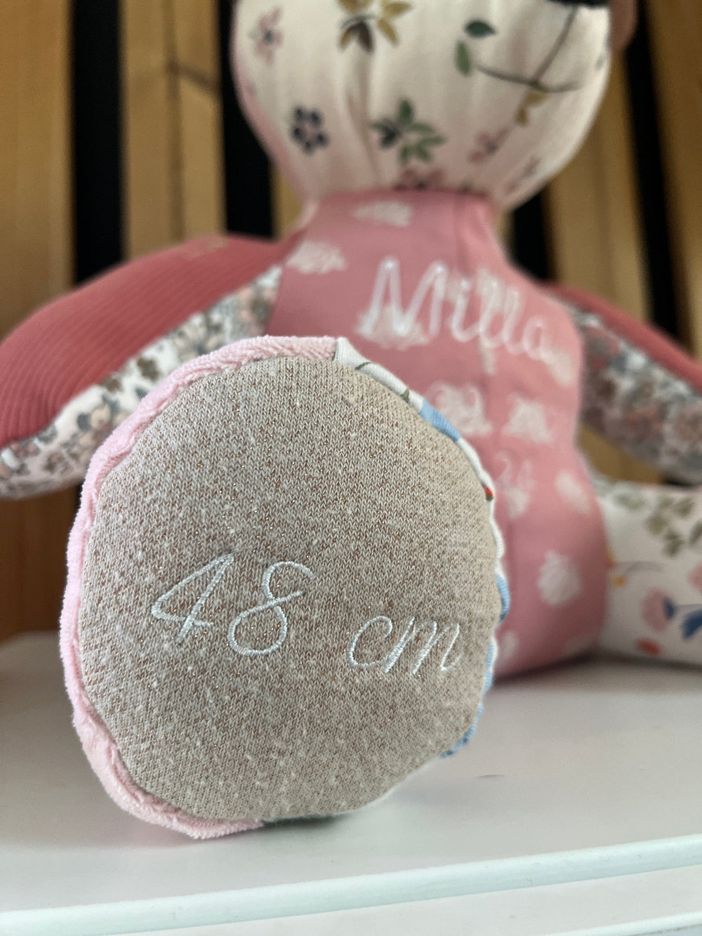 Zoom sur la patte de l'ourson souvenir affichant la taille de naissance de l'enfant en broderie