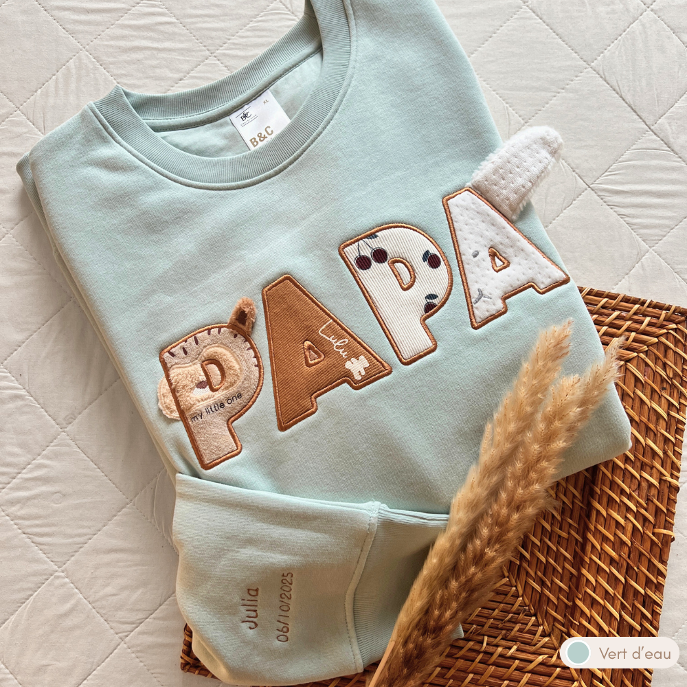 Sweat souvenir personnalisé homme col rond vert d'eau brodé « PAPA », manche brodée prénom et date de naissance, appliqués tissus bébé