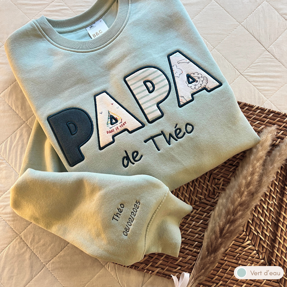 Sweat souvenir personnalisé homme col rond vert d'eau brodé « PAPA de Théo », manche brodée prénom et date de naissance, appliqués voilier
